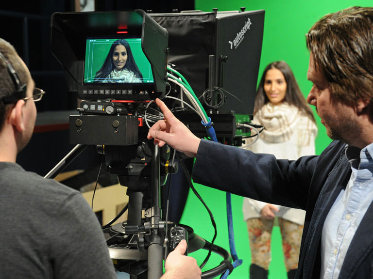 Students and professors collaborate in the broadcast studio.