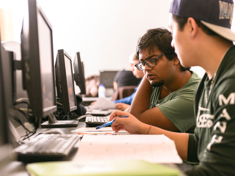 Students work together on a computer science assignment.