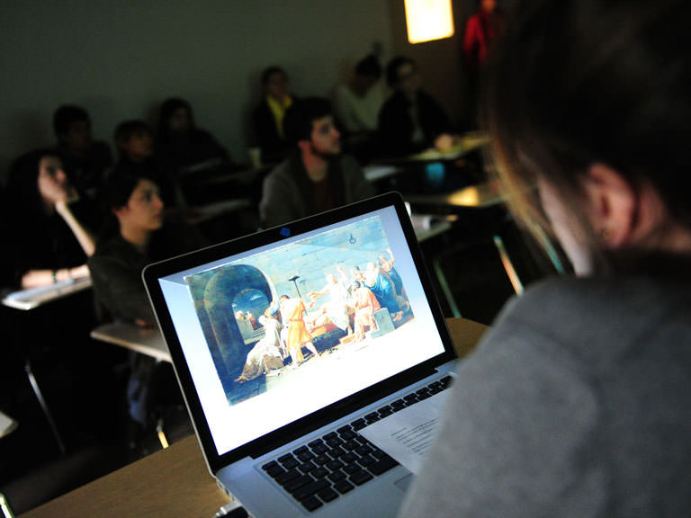 Students view a classical painting on the projector.