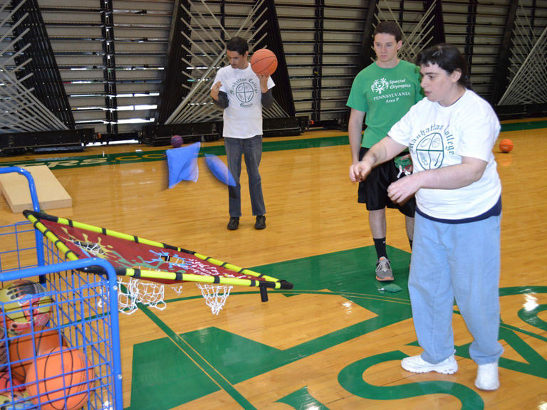 College students play basketball with special needs children. 