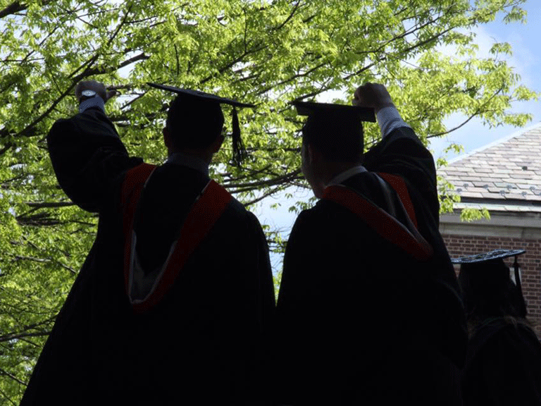 Silhouette of graduates in caps and gowns.