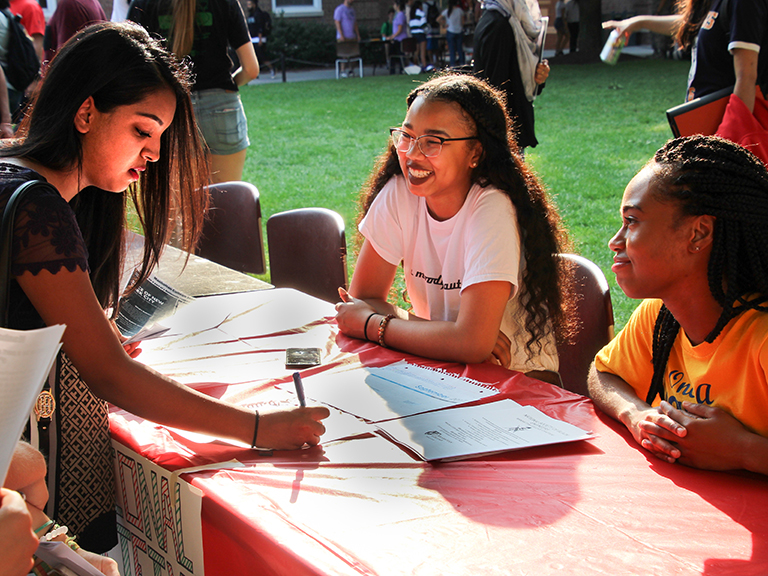 Students engage with each other at club and activities fair on campus.