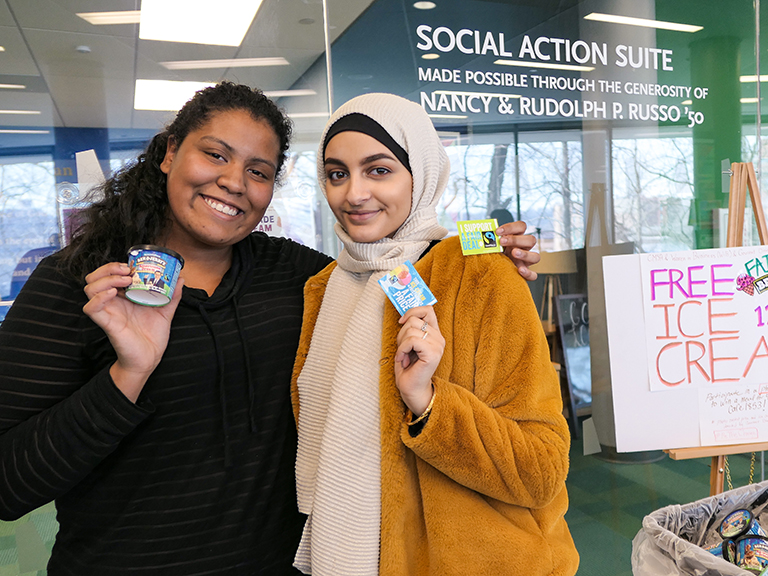 Two students in front of social action suite holding up ice cream for the ice cream social