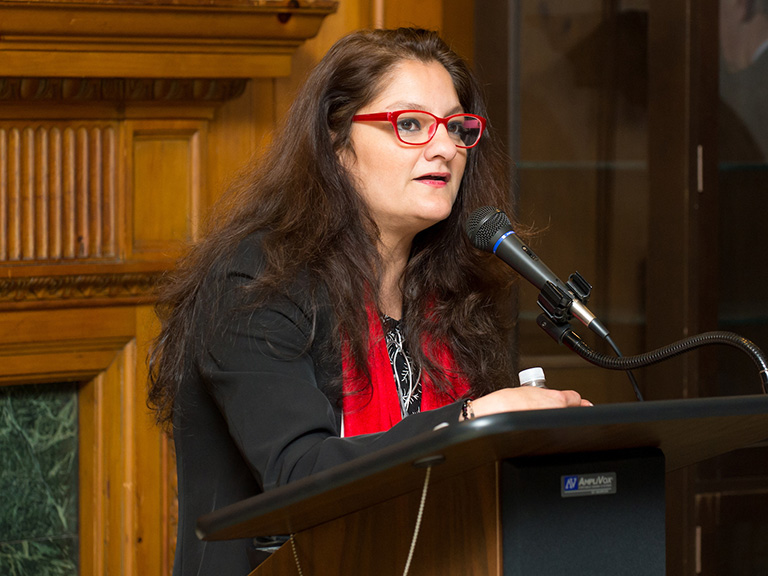 Mehnaz Afridi at podium in O'Malley Library