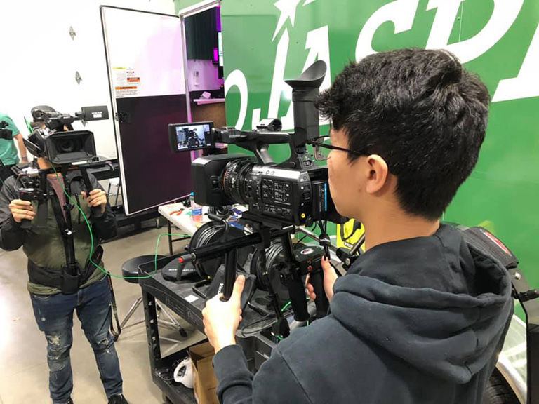 Student operating Television camera for live broadcast.