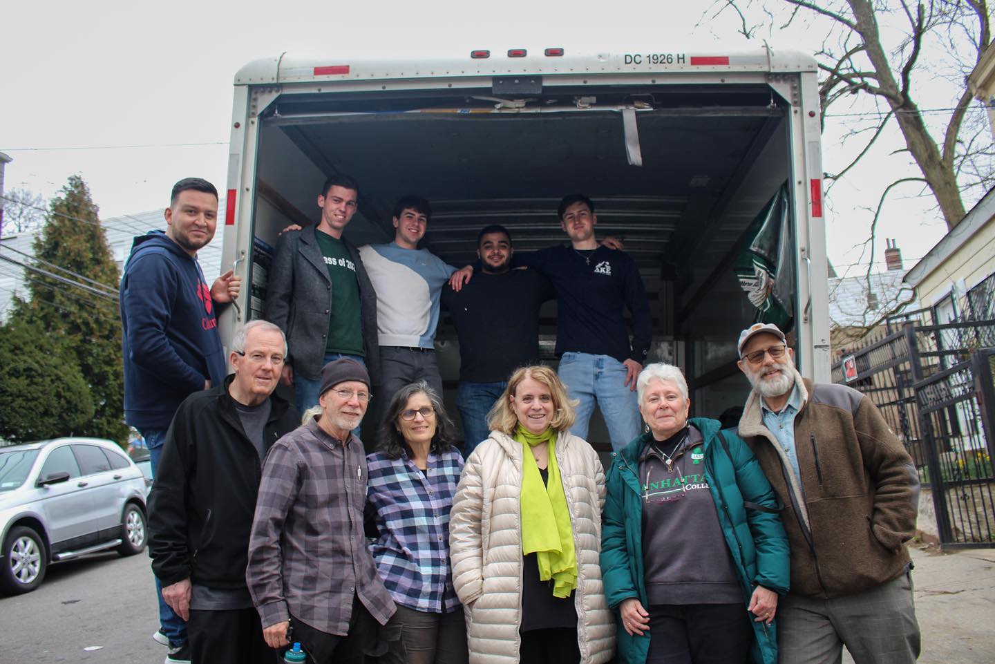 Group helping move furniture into refugees' new home.