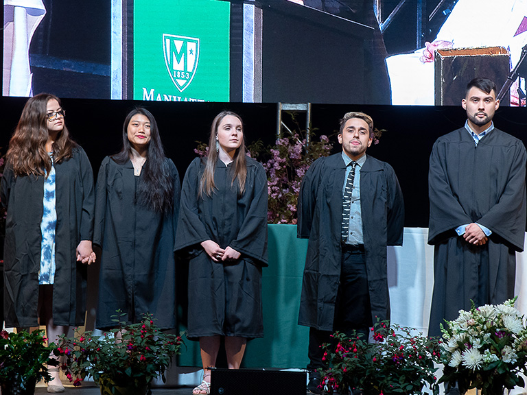 college seniors being recognized on stage at ceremony