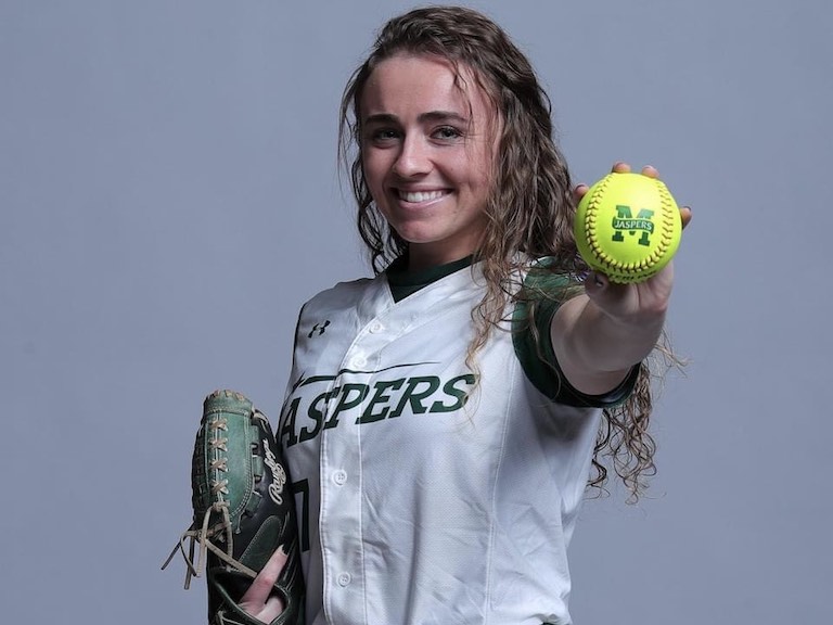 Jessie Rising posing with a Jaspers-branded softball