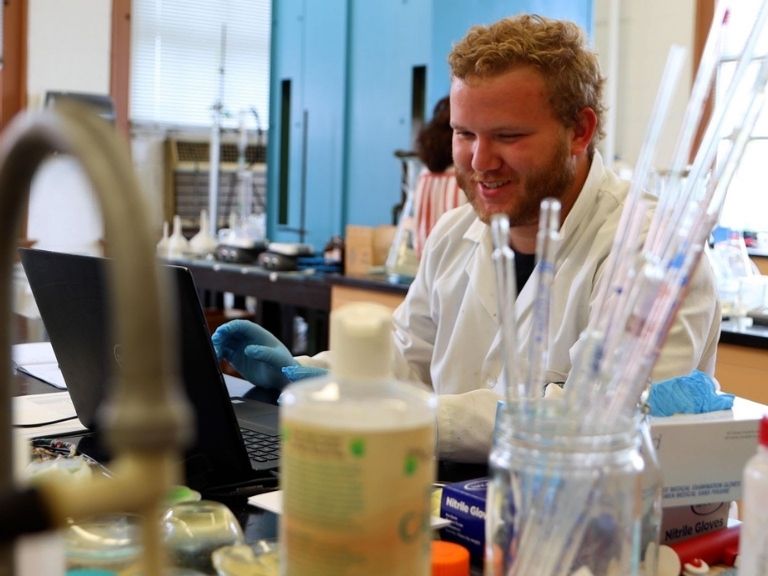 man with blond hair performing experiment in science lab
